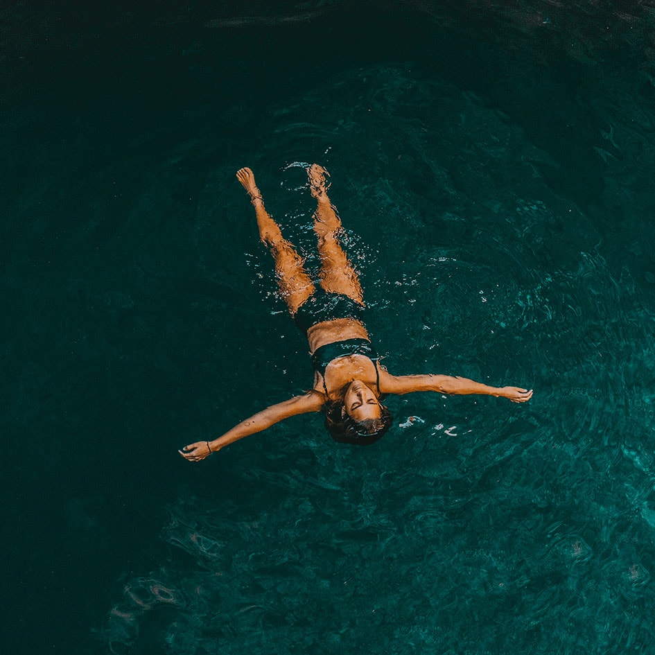 Séjour bien-être, une femme flotte dans l'eau bleue